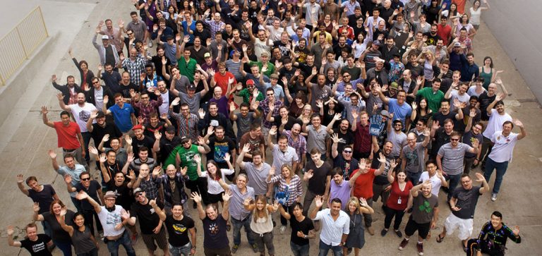 team shot from above with hundreds of Ubisoft Toronto employees waving