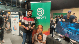 Parth Patel, Online Programmer, poses in front of a Far Cry 6 banner